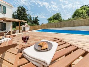 a table with a plate of bread and a glass of wine at Antica holiday house with pool, sea view in Savar