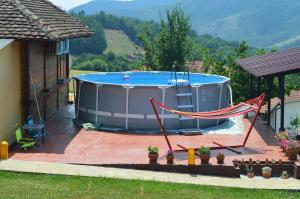 a hot tub with a hammock in front of a house at Kuća Luna in Gornji Milanovac