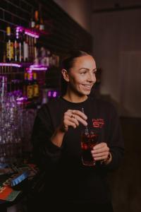 a woman holding a drink in a bar at Hotel Salora in Salo