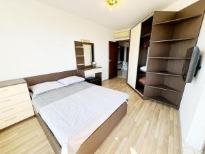 a bedroom with a bed and a tv and shelves at Villa Mare Apartment in St. St. Constantine and Helena