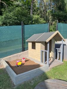 a wooden dog house with a toy in a sandbox at The Houses - Chata u sjezdovky 2 in Velké Meziříčí