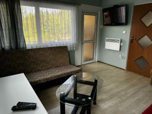 a living room with a couch and a glass table at Domek nad jeziorem Mausz z Balią in Parchowo