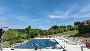 a swimming pool with orange chairs at Garda Hill Boutique Apartments with Panoramic Pools e Agriturismo in Soiano del Lago