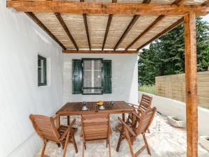 a patio with a wooden table and chairs at Antica holiday house with pool, sea view in Savar