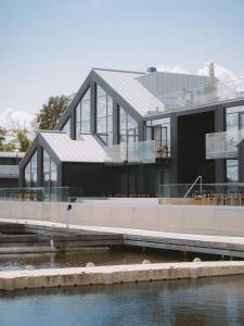 a house on the water next to a body of water at Season Hotel in Ekerö