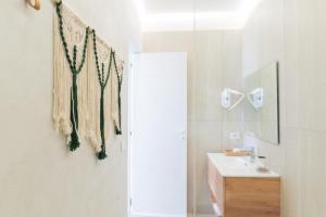 a white bathroom with a sink and a mirror at AYLA Suite - Panoramic Luxury Escape in Baia +32 photos