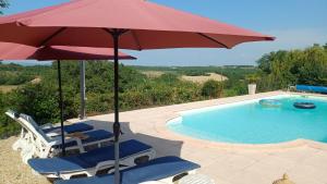 un gruppo di sedie e un ombrellone accanto alla piscina di Chambre indépendante, au calme douillette et confort a Itzac