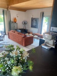 a living room with a couch and a table with flowers at Le Loft Corail in Jullouville-les-Pins
