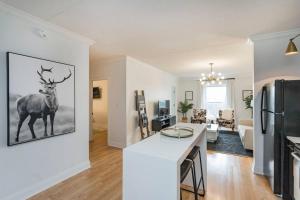 cocina y sala de estar con un ciervo en la pared en Two Condos on Music Row that Sleeps 14 with POOL and Parking, en Nashville