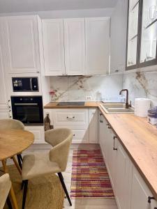 eine Küche mit weißen Schränken und einem Tisch und Stühlen in der Unterkunft Crystal Pool Villa Bay of Lalzi in Draç