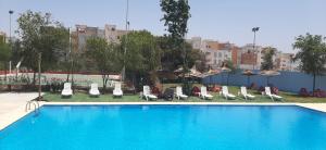 a large swimming pool with chairs and umbrellas at Résidence Sable d'or in Hauara