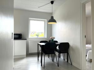 a dining room with a table and black chairs at Spacious Apartment for 4 in Aalborg