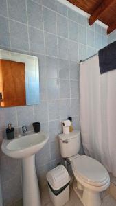Un baño con un inodoro blanco y un lavabo. en Cabañas Anka, en San Pedro de Atacama