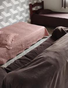 two beds sitting next to each other in a bedroom at Casa aconchegante no distrito Sobradinho de Minas in São Thomé das Letras