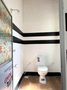 baño con aseo y rayas en blanco y negro en Holiday In Nilaveli Resort, en Trincomalee
