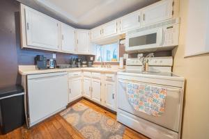a kitchen with white cabinets and white appliances at Springwells Park Townhouse Very Cozy in Dearborn