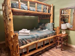 ein Schlafzimmer mit zwei Etagenbetten und einem Tisch in der Unterkunft Laurelwood Luxury Cabin Hot Tub in Cosby