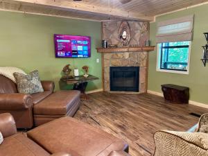 ein Wohnzimmer mit Couch und Kamin in der Unterkunft Laurelwood Luxury Cabin Hot Tub in Cosby