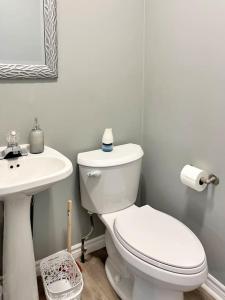 a bathroom with a white toilet and a sink at Cozy Retreat with Netflix and Work Desk in Fort Erie