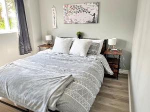 a bedroom with a bed with a gray comforter and pillows at Cozy Retreat with Netflix and Work Desk in Fort Erie