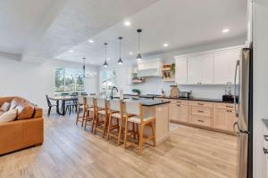 une cuisine avec des armoires blanches et une table avec des chaises dans l'établissement Dream Bear Lake Getaway w/ Hot Tub & Yard, à Garden City