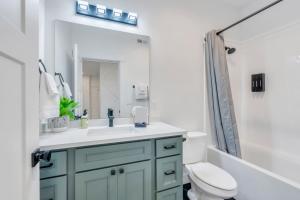 une salle de bain avec un lavabo, des toilettes et un miroir dans l'établissement Dream Bear Lake Getaway w/ Hot Tub & Yard, à Garden City 51 autres photos