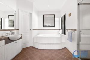 a white bathroom with a tub and a sink at Valletta View in Halls Head in Mandurah +25 photos
