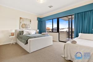 a bedroom with two beds and a large window at Valletta View in Halls Head in Mandurah