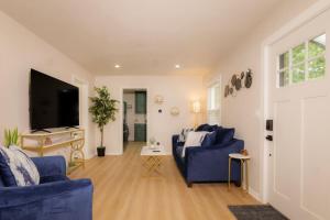een woonkamer met twee blauwe banken en een tv bij Heights Haven on Paris - 2BD Stay in Peoria Heights