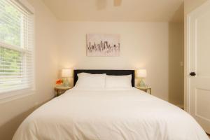 een slaapkamer met een groot wit bed met twee lampen bij Heights Haven on Paris - 2BD Stay in Peoria Heights