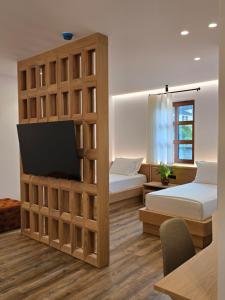a room with two beds and a flat screen tv at Palorto Inn in Gjirokastër