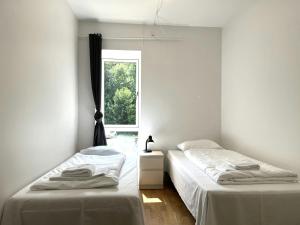 two beds in a room with a window at Spacious Apartment for 8 in Eternitten in Aalborg