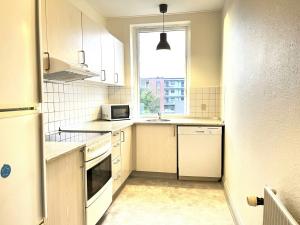 a kitchen with white appliances and a window at Spacious Apartment for 6 in Frederikshavn +5 photos