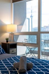a bedroom with a bed with a desk and a window at Ent District 3 Bedroom 2Bath Parking CN Tower in Toronto