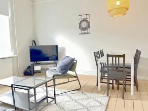 Una sala de estar con una mesa y un comedor. en Spacious Apartment for 6, en Frederikshavn