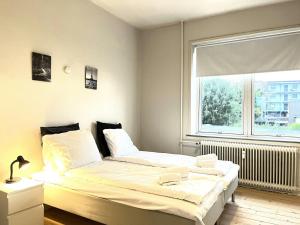Un dormitorio con dos camas y una gran ventana. en Spacious Apartment for 6, en Frederikshavn