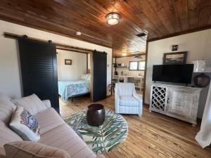 ein Wohnzimmer mit Sofa und Fernseher in der Unterkunft The Historic Gibbs Cottages 7 in Port Aransas