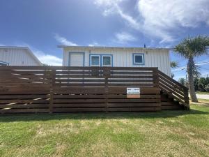 ein Holzzaun vor einem Haus in der Unterkunft The Historic Gibbs Cottages 7 in Port Aransas + 3 Fotos
