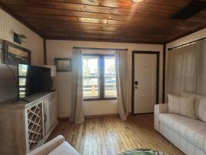 ein Wohnzimmer mit einer Couch und einem Fenster in der Unterkunft The Historic Gibbs Cottages 7 in Port Aransas