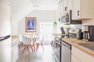 a kitchen with white cabinets and a table and chairs at Penthouse Apartment in Stowe in Stowe
