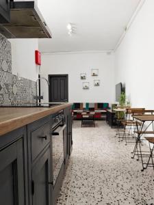 a kitchen with a counter and some tables and chairs at Cosy Room 8 in Tal-Pietà