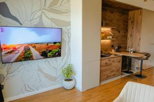 a living room with a flat screen tv on a wall at Luna Residence in Niš