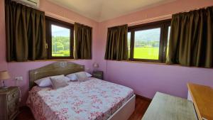 una camera da letto con un letto e due finestre di Foresteria Villa Simona a Colico