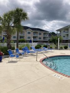 - un groupe de chaises et une piscine dans un complexe dans l'établissement Salty Air Retreat by the beach, à Myrtle Beach