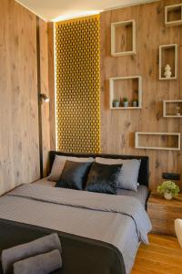 a large bed in a room with wooden walls at Luna Residence in Niš +21 photos
