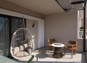 a room with a swing and a table and chairs at Olenia Suites in Neos Marmaras