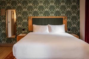 a bedroom with a large white bed and a wallpaper at Hotel Edison Times Square in New York