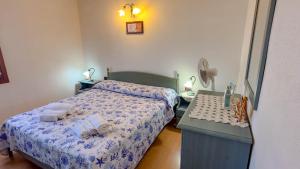 a bedroom with two beds and a table with towels at Casa Tombolini in Limpiddu