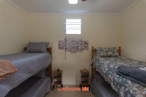 a bedroom with two beds and a window at Chácara em São Pedro com piscina e churrasqueira in São Pedro