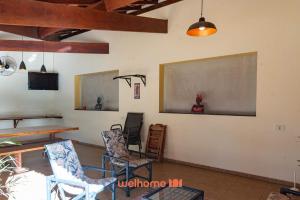 a room with chairs and a table and a chalkboard at Chácara em São Pedro com piscina e churrasqueira in São Pedro